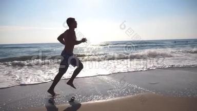 早上在海边跑步的运动<strong>青年</strong>。 在阳光明媚的<strong>日</strong>子里，运动员沿着海岸慢跑。 男运动员
